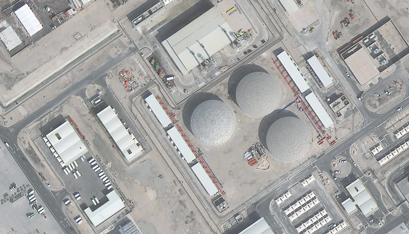 Satellite image of an industrial site in Qatar with large spherical storage tanks, pipework, and warehouses