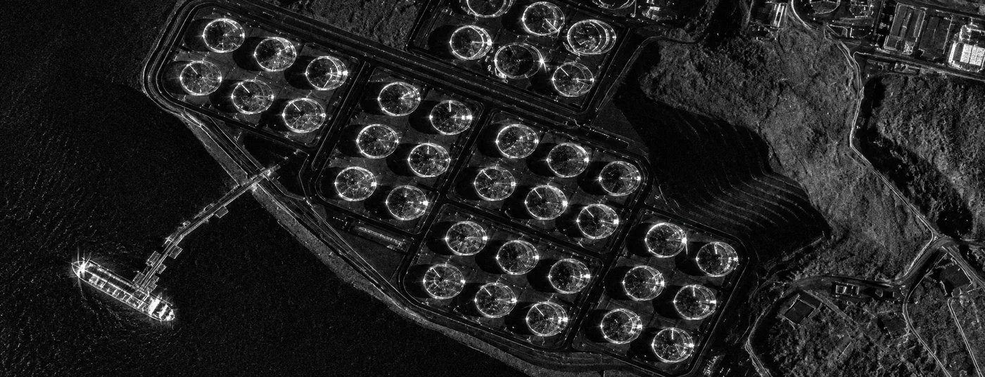 Black and white synthetic aperture radar satellite image of a large industrial facility captured at night, illustrating all-weather radar imaging used for emergency response
