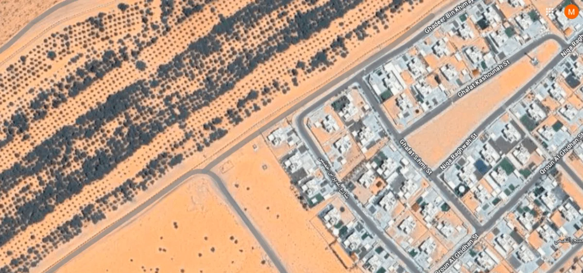 Satellite stereo imagery showing agricultural rows transitioning into a residential development, used for terrain and drainage-aware planning